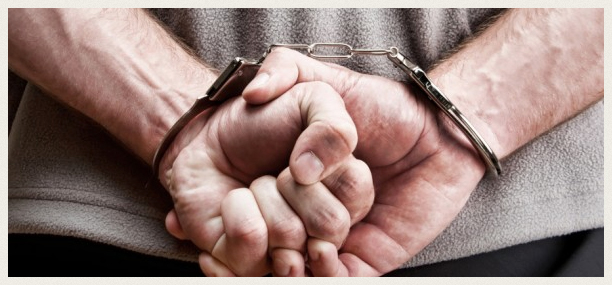 Man with clenched fists handcuffed behind his back